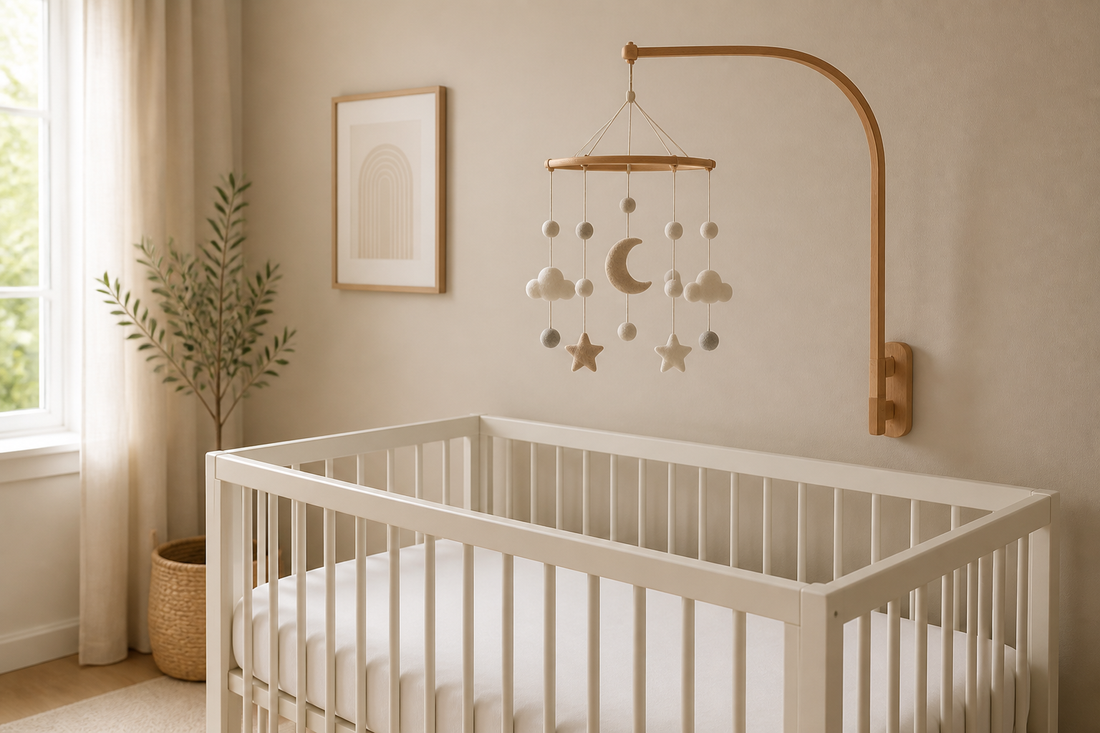 Soft modern nursery with a bare crib and a baby mobile mounted high above the mattress, clearly out of baby's reach