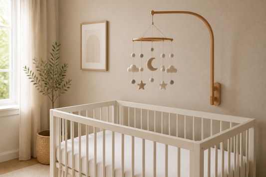 Soft modern nursery with a bare crib and a baby mobile mounted high above the mattress, clearly out of baby's reach