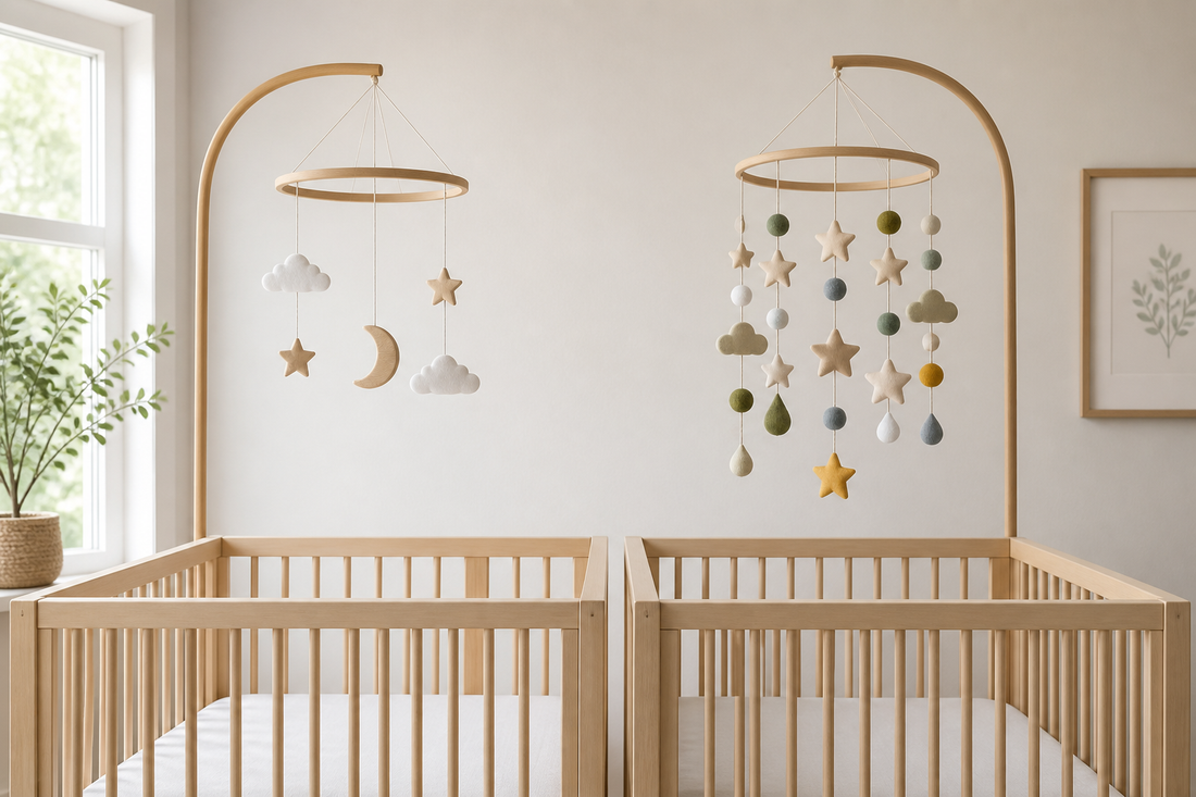 Soft modern nursery with a safe bare crib and two baby mobiles showing a simple design beside a busier layered design in gentle daylight